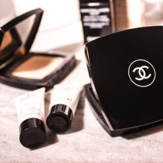 women's Chanel pressed powder beside tube bottles